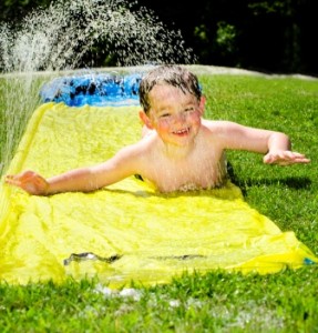 bigstock-Happy-child-on-water-slide-to--32587520